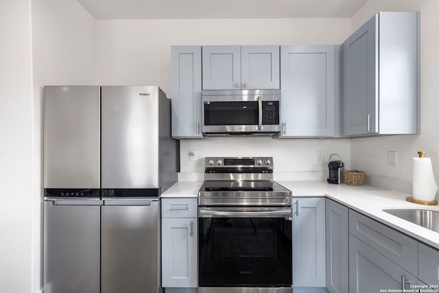 kitchen with appliances with stainless steel finishes and gray cabinetry