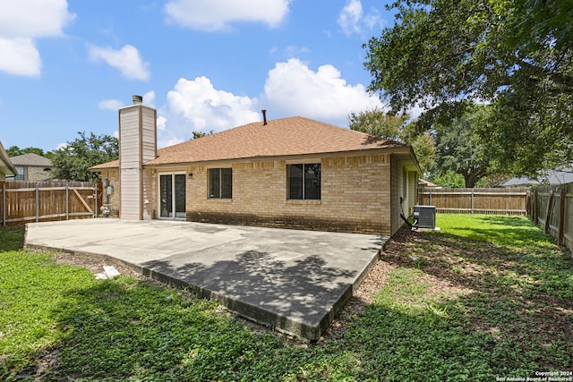 rear view of house with a patio, a yard, and central AC