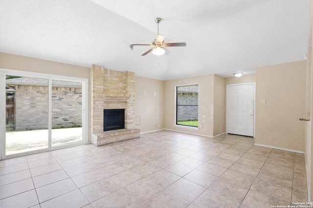 unfurnished living room featuring light tile patterned floors, ceiling fan, a fireplace, a textured ceiling, and vaulted ceiling