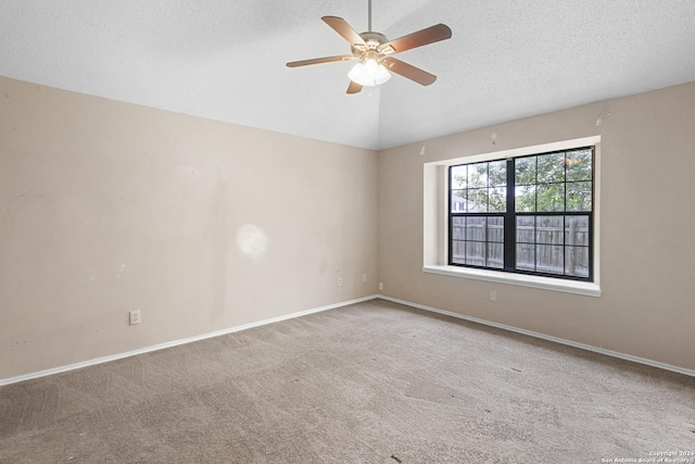 unfurnished room featuring ceiling fan, lofted ceiling, carpet, and a textured ceiling