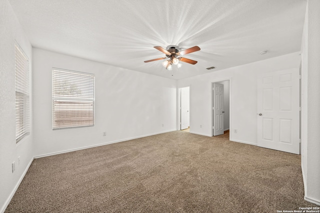 unfurnished bedroom featuring ceiling fan, carpet, and a textured ceiling