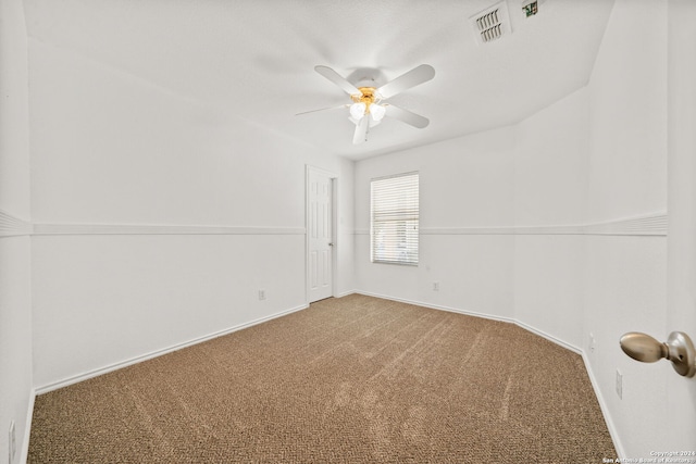 carpeted spare room with ceiling fan