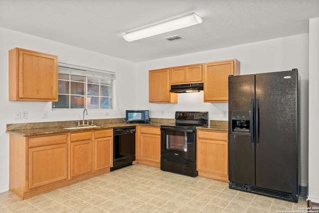 kitchen with dark stone counters, sink, a textured ceiling, and black appliances