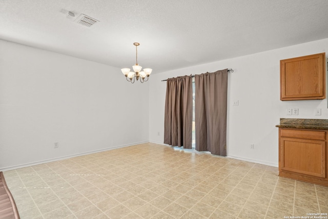 interior space featuring a notable chandelier and a textured ceiling