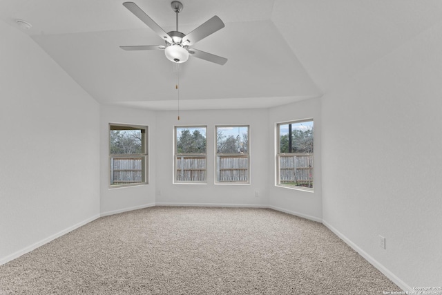 carpeted spare room featuring ceiling fan and vaulted ceiling