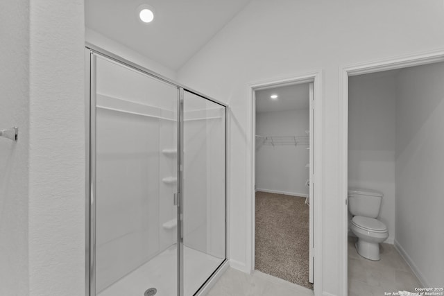 bathroom featuring toilet, walk in shower, and tile patterned flooring