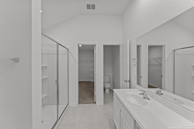 bathroom with toilet, tile patterned floors, a shower with shower door, and vanity