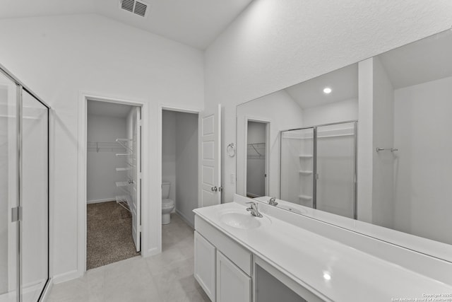 bathroom with toilet, a shower with shower door, and vanity