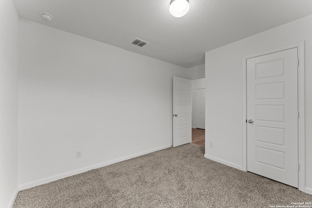 carpeted spare room with a textured ceiling