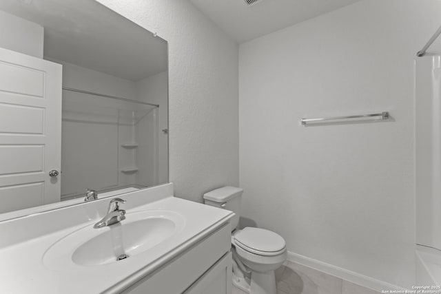 bathroom featuring toilet, vanity, and tile patterned flooring