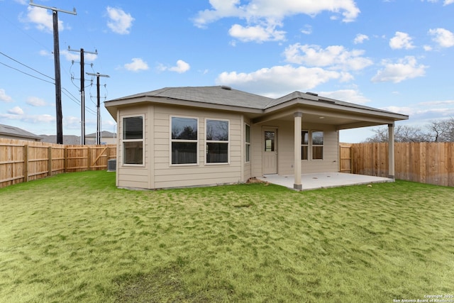 back of house with a patio area, a lawn, and central AC