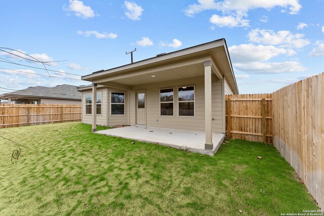 rear view of property featuring a patio area and a lawn