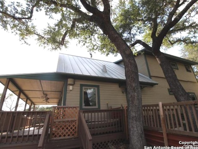 view of property exterior with a wooden deck and ceiling fan