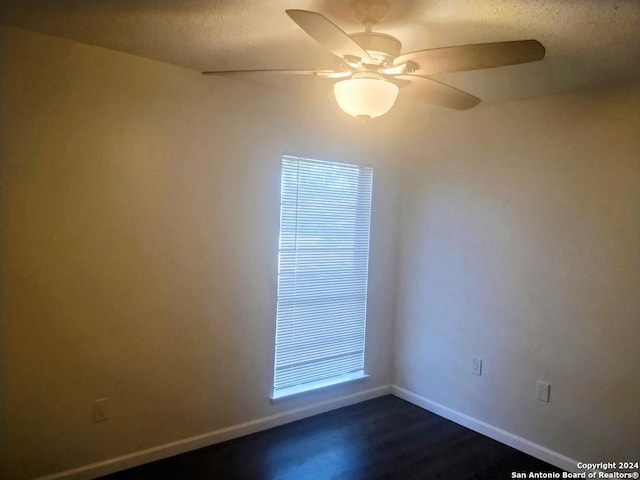 empty room featuring ceiling fan, dark hardwood / wood-style flooring, and a textured ceiling