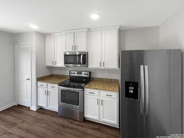 kitchen with stainless steel appliances, dark hardwood / wood-style floors, dark stone countertops, and white cabinets