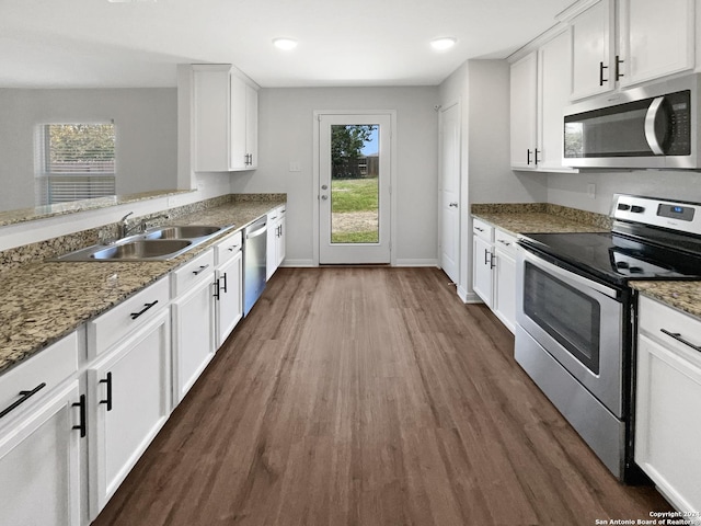 kitchen featuring white cabinetry, appliances with stainless steel finishes, sink, and dark stone countertops