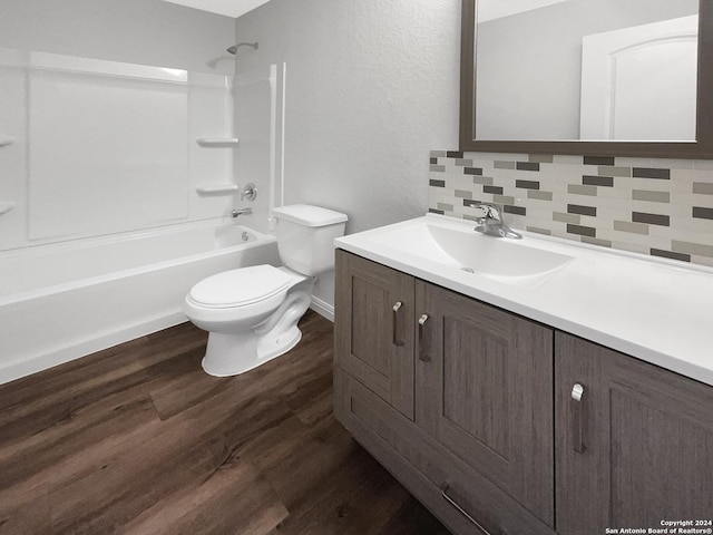 full bathroom with shower / washtub combination, backsplash, hardwood / wood-style flooring, vanity, and toilet