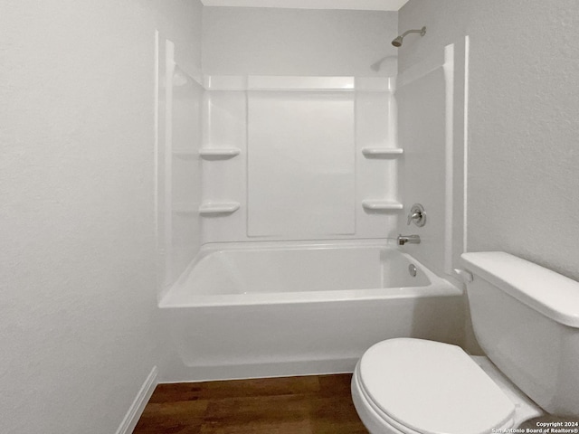 bathroom featuring wood-type flooring,  shower combination, and toilet