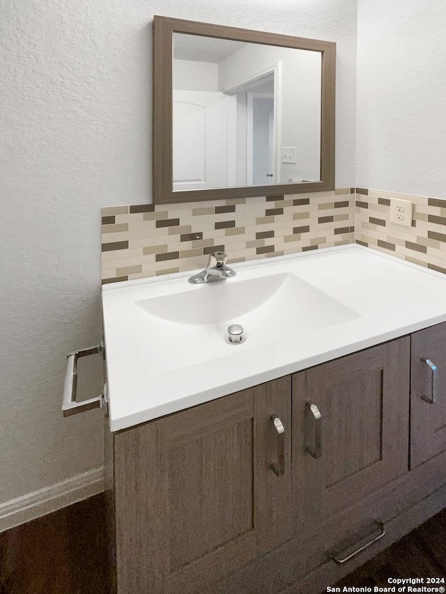 bathroom with vanity and tasteful backsplash