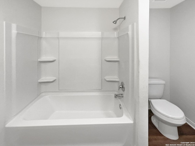 bathroom featuring hardwood / wood-style flooring,  shower combination, and toilet