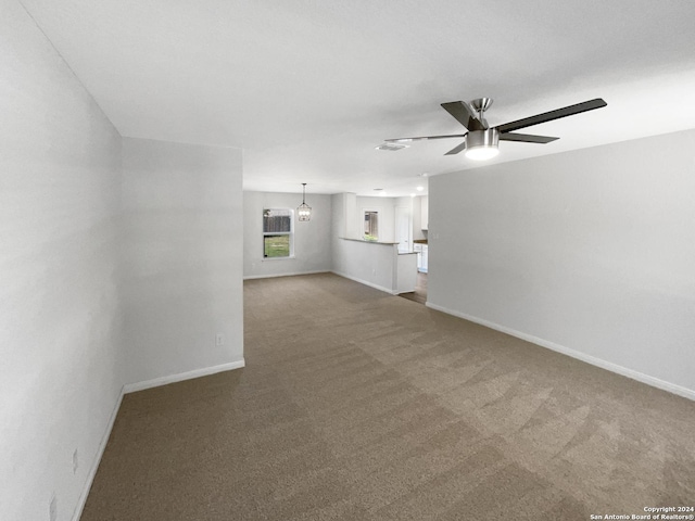 unfurnished living room featuring ceiling fan and carpet