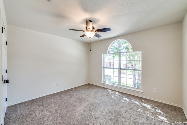 carpeted spare room with a textured ceiling and ceiling fan