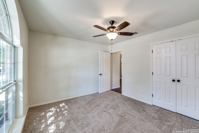 unfurnished bedroom featuring a closet, carpet floors, and ceiling fan