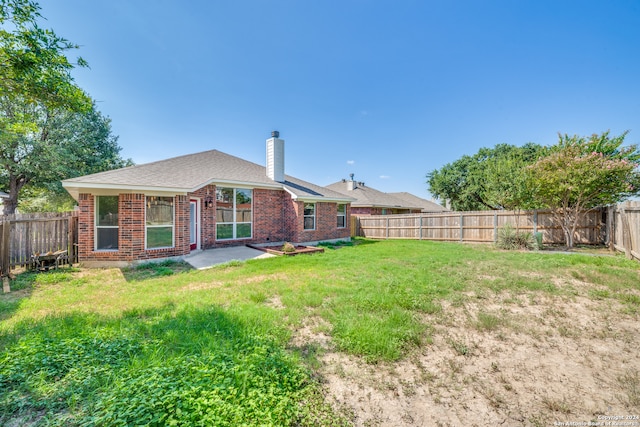 back of property featuring a yard and a patio