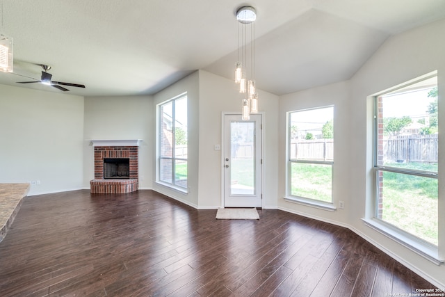 unfurnished living room featuring ceiling fan, dark wood-type flooring, a brick fireplace, and lofted ceiling