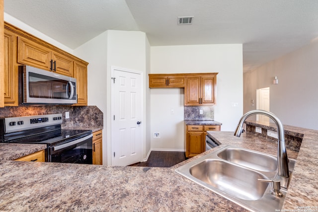 kitchen with stainless steel appliances, backsplash, sink, and dark wood-type flooring