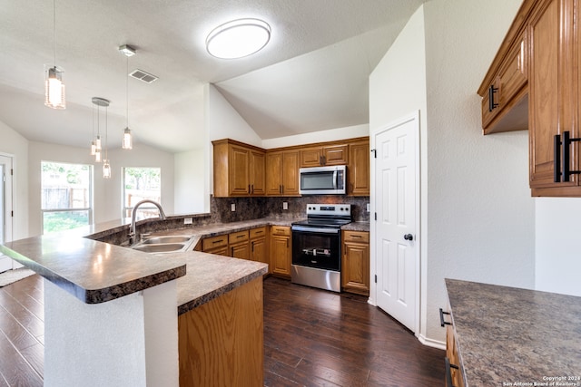 kitchen with decorative backsplash, sink, vaulted ceiling, appliances with stainless steel finishes, and dark wood-type flooring