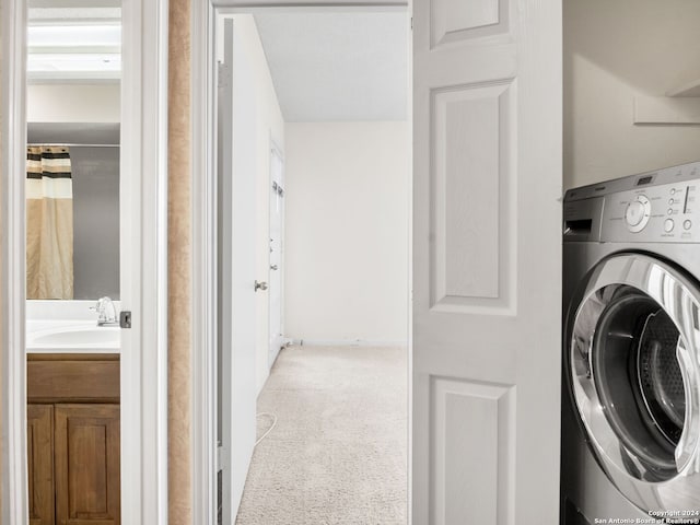 clothes washing area featuring sink, carpet flooring, and washer / dryer