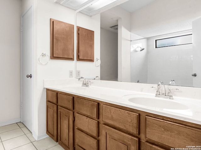 bathroom with tile patterned floors and dual bowl vanity