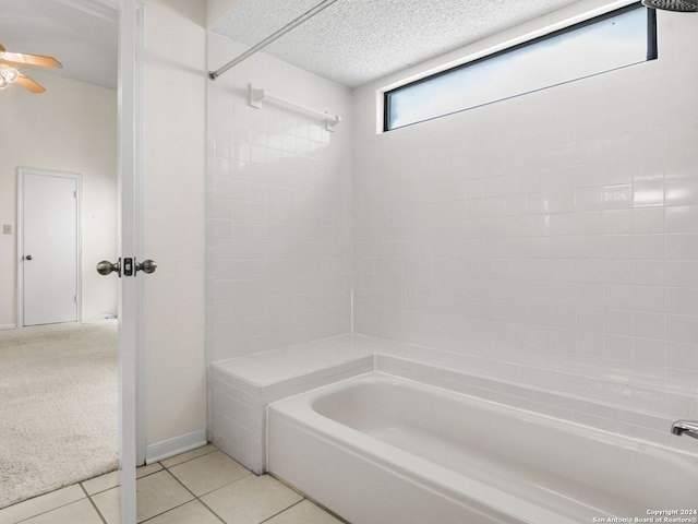 bathroom featuring tiled shower / bath combo, tile patterned floors, and a textured ceiling