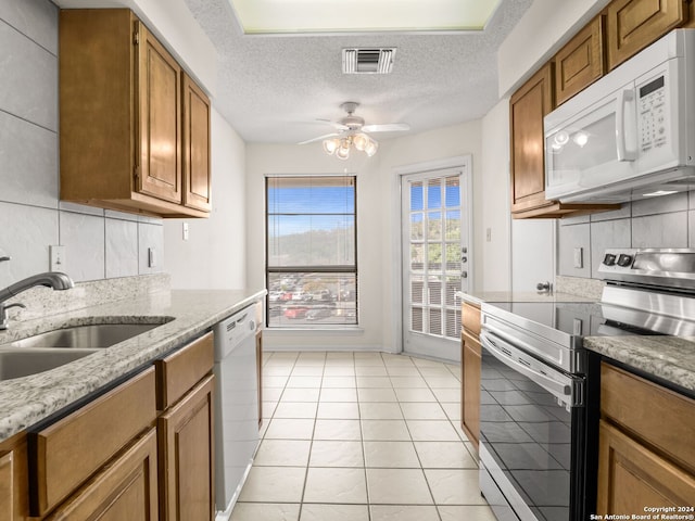 kitchen with backsplash, a textured ceiling, white appliances, and ceiling fan