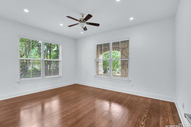 unfurnished room featuring dark hardwood / wood-style flooring, a wealth of natural light, and ceiling fan