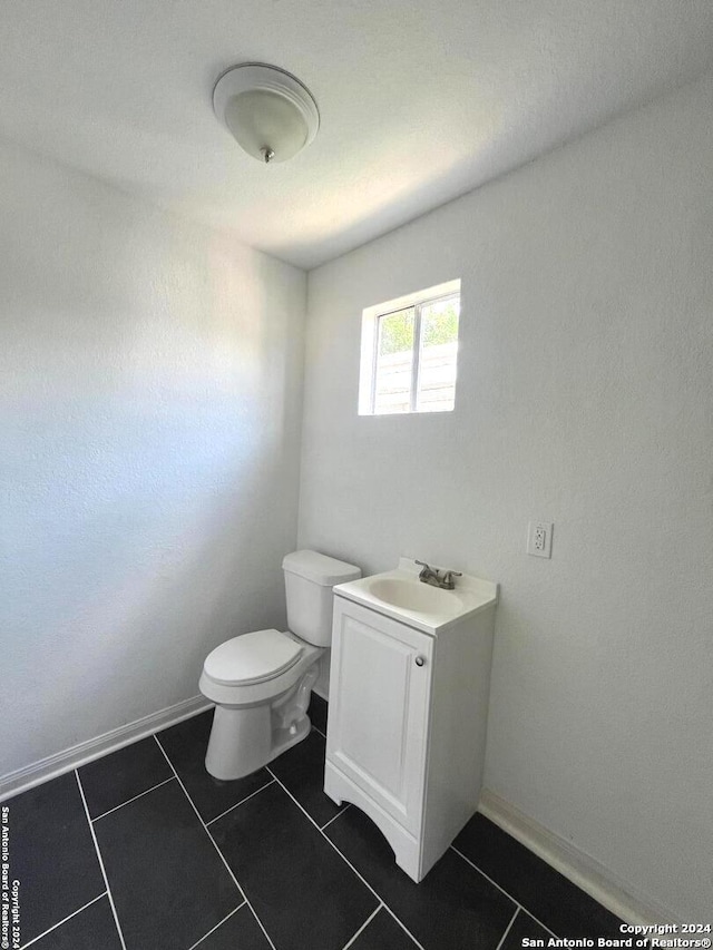 bathroom with vanity, tile patterned flooring, and toilet