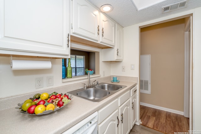 kitchen with sink, a textured ceiling, white cabinets, and light hardwood / wood-style floors