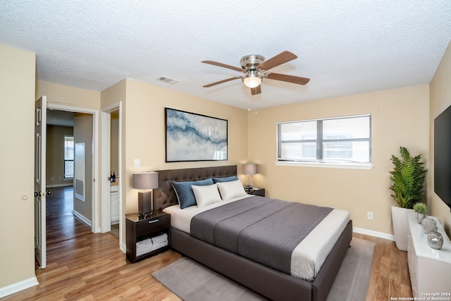 bedroom featuring a textured ceiling, light hardwood / wood-style flooring, and ceiling fan