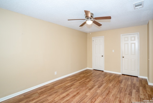 empty room featuring light hardwood / wood-style floors, a textured ceiling, and ceiling fan