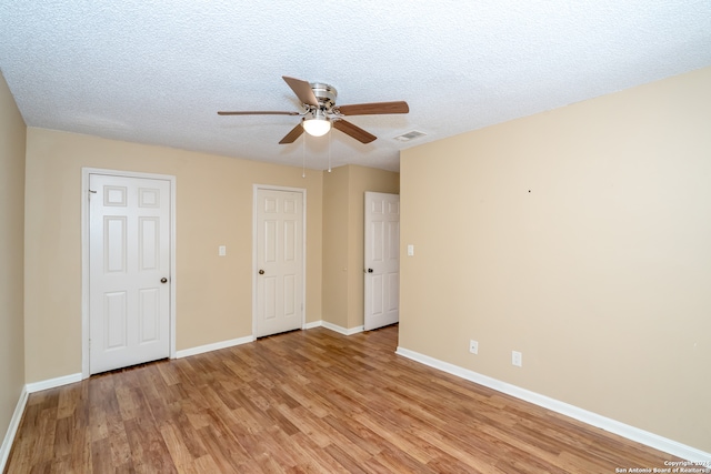 unfurnished bedroom with light wood-type flooring, ceiling fan, and a textured ceiling