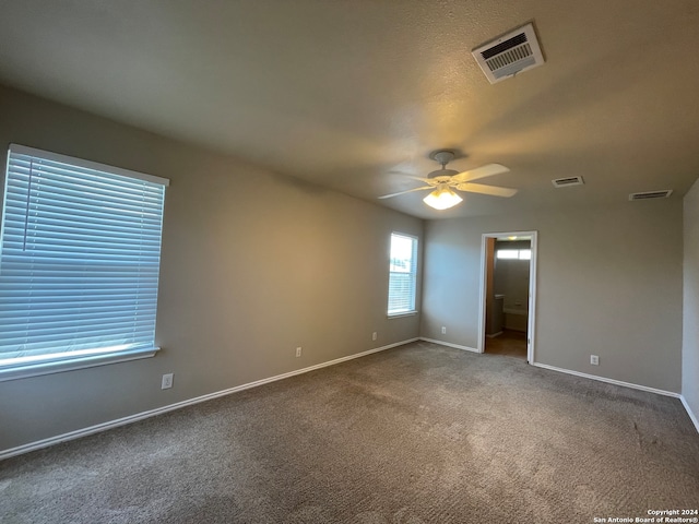 carpeted spare room featuring ceiling fan