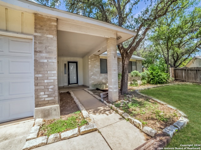 doorway to property featuring a garage and a yard