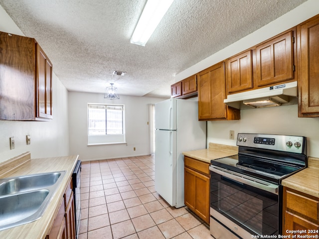 kitchen featuring light tile patterned floors, a textured ceiling, dishwasher, electric stove, and white refrigerator