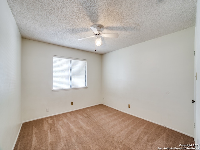 carpeted empty room with a textured ceiling and ceiling fan