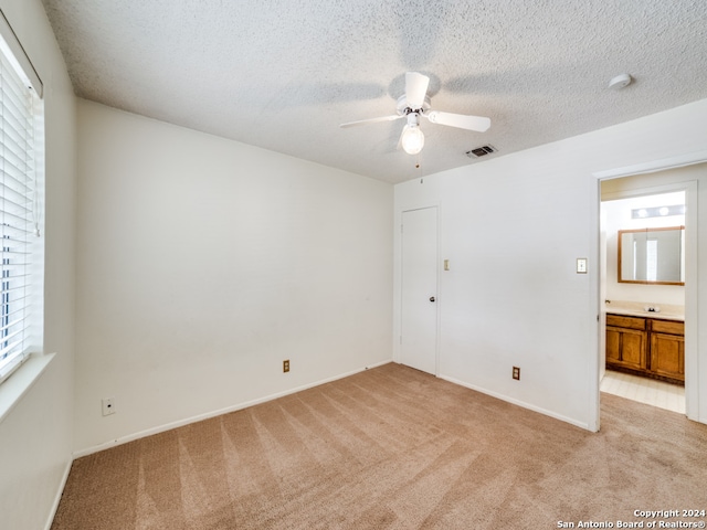 interior space with light colored carpet, a textured ceiling, and ceiling fan