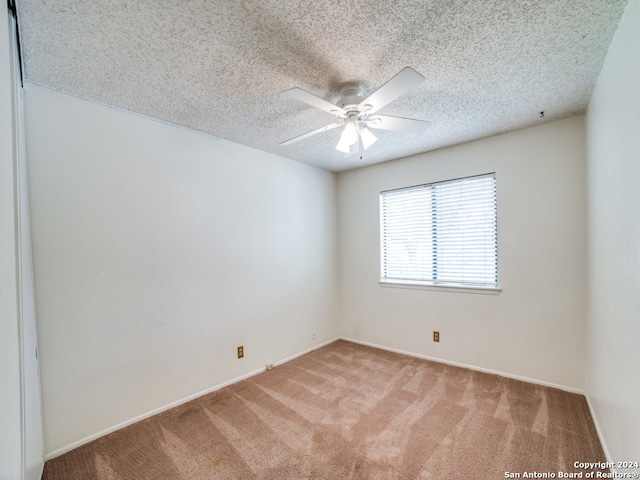 carpeted empty room featuring a textured ceiling and ceiling fan