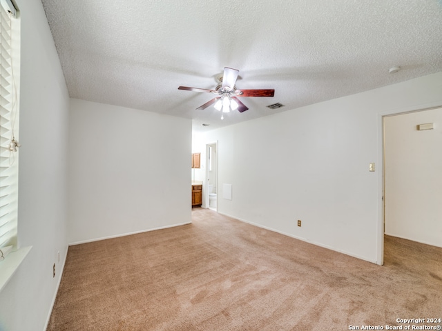 carpeted spare room featuring a textured ceiling and ceiling fan