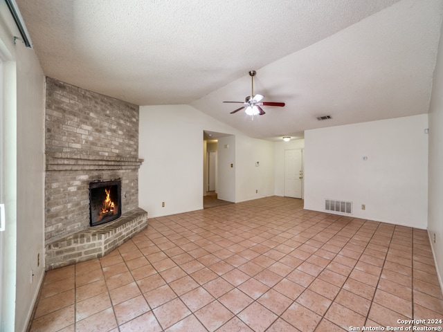 unfurnished living room featuring light tile patterned flooring, ceiling fan, a brick fireplace, and vaulted ceiling