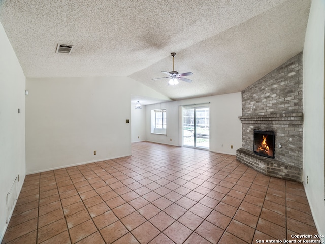 unfurnished living room with tile patterned flooring, a brick fireplace, and lofted ceiling